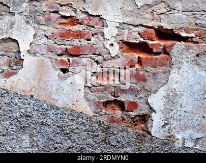 Beau vieux mur patiné avec des motifs de maçonnerie, du plâtre qui s'effrite et de la peinture écaillée, beauté de l'architecture ancienne en décomposition Banque D'Images