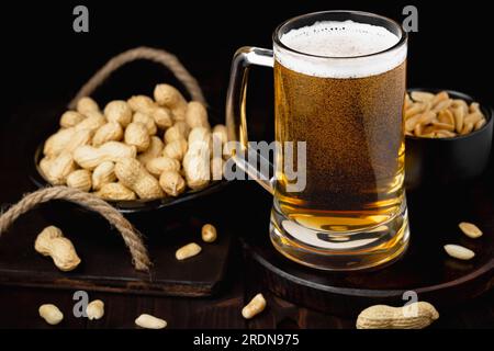 Tasse de bière avec mousse et cacahuètes fond Pub Banque D'Images