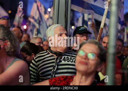 Tel Aviv, Israël. 22 juillet 2023. Un manifestant israélien vêtu d'un masque représentant le Premier ministre israélien Benjamin Netanyahu participe à une manifestation contre les plans du gouvernement de Netanyahu de réformer le système judiciaire. Crédit : Ilia Yefimovich/dpa/Alamy Live News Banque D'Images