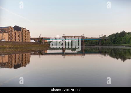 Train de sprinter de classe 156 du Northern Rail traversant le pont Carlisle (Lancaster, rivière Lune) sur la ligne principale de la côte ouest avec saint Georges Quay, Lancaster. Banque D'Images