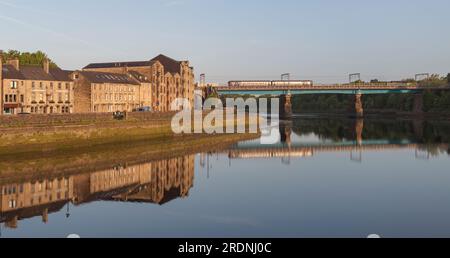 Train de sprinter de classe 156 du Northern Rail traversant le pont Carlisle (Lancaster, rivière Lune) sur la ligne principale de la côte ouest avec saint Georges Quay, Lancaster. Banque D'Images