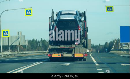 St. Petersburg, Russie - octobre 23 2019 : voitures de tourisme chargées, transporteur de voitures sur la route. Vue arrière Banque D'Images