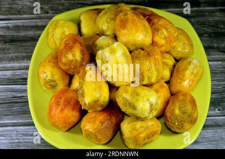 Un tas de fruits de Barbarie frais pelés dans une assiette isolée sur fond en bois, Opuntia, communément appelé poire de Barbarie, fruit de thon, sa Banque D'Images