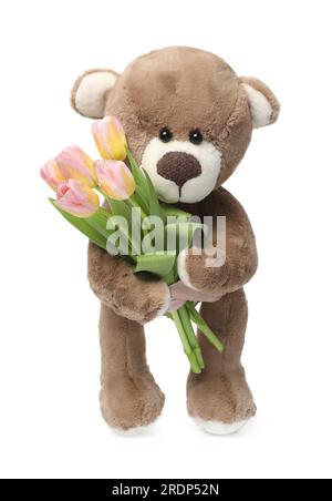 Mignon ours en peluche avec de belles tulipes isolé sur blanc Banque D'Images