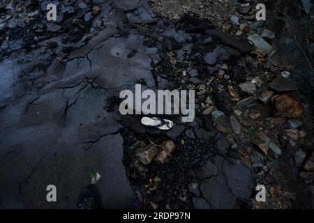 Srinagar, Inde. 22 juillet 2023. Shoes repose sur une route endommagée par des crues soudaines après un nuage à la périphérie de Srinagar, Cachemire contrôlé par l’Inde, samedi 22 juillet 2023. Des crues soudaines et des nuages dans le Cachemire indien ont endommagé les cultures et coupé les routes. Aucune victime n ' a été signalée. (Photo de Mubashir Hassan/Pacific Press) crédit : Pacific Press Media production Corp./Alamy Live News Banque D'Images