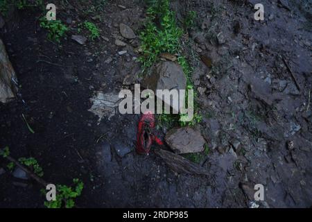 Srinagar, Inde. 22 juillet 2023. Shoes repose sur une route endommagée par des crues soudaines après un nuage à la périphérie de Srinagar, Cachemire contrôlé par l’Inde, samedi 22 juillet 2023. Des crues soudaines et des nuages dans le Cachemire indien ont endommagé les cultures et coupé les routes. Aucune victime n ' a été signalée. (Photo de Mubashir Hassan/Pacific Press) crédit : Pacific Press Media production Corp./Alamy Live News Banque D'Images