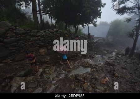 Srinagar, Inde. 22 juillet 2023. Des villageois cachemiris marchent sur une route endommagée par des crues soudaines après un nuage à la périphérie de Srinagar, Cachemire contrôlé par les Indiens, samedi 22 juillet 2023. Des crues soudaines et des nuages dans le Cachemire indien ont endommagé les cultures et coupé les routes. Aucune victime n ' a été signalée. (Photo de Mubashir Hassan/Pacific Press) crédit : Pacific Press Media production Corp./Alamy Live News Banque D'Images