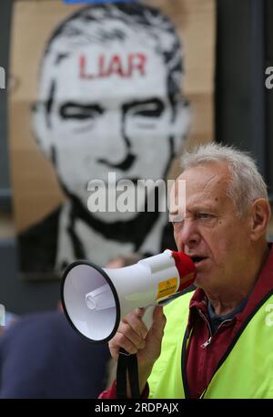 Londres, Royaume-Uni. 22 juillet 2023. Un manifestant parle à la foule rassemblée à travers un mégaphone avec un grand portrait de Sadiq Khan avec «menteur» écrit sur son front en arrière-plan à l'extérieur de la BBC. Les manifestants s'unissent pour faire comprendre au maire de Londres Sadiq Khan que lui et l'extension de la zone à ultra-faibles émissions (ULEZ) existante à Londres ne sont pas désirés. Le maire Khan étend la zone en août 2023 en vue d'améliorer la qualité de l'air du Grand Londres. Crédit : SOPA Images Limited/Alamy Live News Banque D'Images