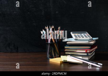 Retour à l'arrière-plan de l'école avec des livres sur la table en bois sur le tableau noir Banque D'Images