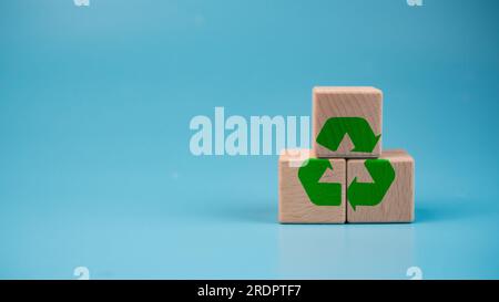 Blocs de bois empilés avec symbole de recyclage vert. Concept de recyclage. Banque D'Images