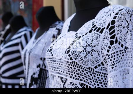 Hauts en dentelle décorés blancs sur des poupées de mode noires devant une vitrine Banque D'Images