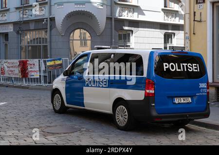 La voiture de police surveille les manifestations dans la rue de l'ambassade de Russie à Tallinn. Des bannières et des affiches sont suspendues aux clôtures parce que les Russes ont envahi l'Ukraine Banque D'Images