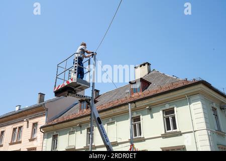 Villach, Autriche. Juillet 18 2023. un technicien s’est soulevé sur un panier alors qu’il travaillait sur des câbles électriques dans une rue du centre-ville Banque D'Images