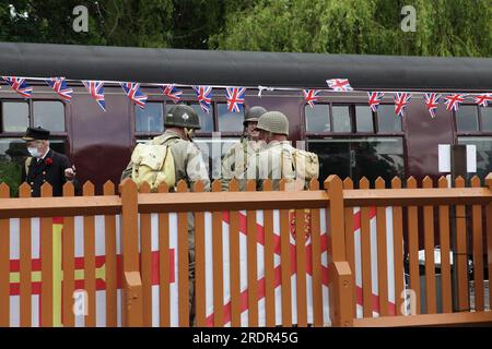 Les passionnés habillés en SIG américains discutent lors de l'arrêt à Arley Station pendant la journée des années 1940 de la Severn Valley Railway. Banque D'Images