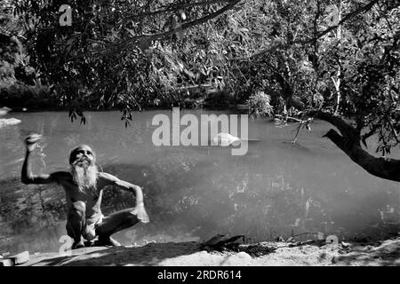 Vieux vintage des années 1900 photo en noir et blanc du prêtre indien effrayant singe assis arbre rivière Mandakini Chitrakoot Satna Madhya Pradesh Inde Banque D'Images