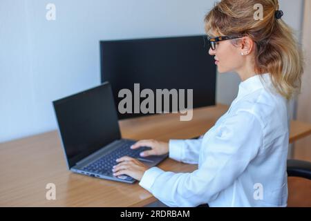 femme d'affaires travaillant sur ordinateur portable dans son poste de travail. Banque D'Images