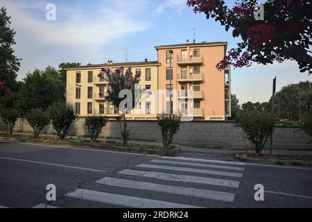 Bâtiment usé avec une clairière en face de lui dans un quartier résidentiel au coucher du soleil Banque D'Images