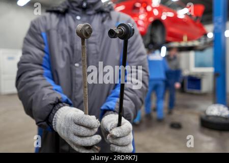 Nouvelle et ancienne barre stabilisatrice ou bras de liaison prêt à remplacer dans la suspension de voiture sur la table en métal dans le garage pour la réparation et l'entretien. Pièce de voiture et Banque D'Images