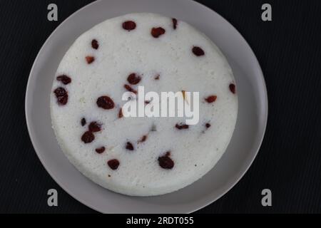 Vattayappam. Gâteau de riz spongieux cuit à la vapeur recouvert de canneberges séchées. Une collation traditionnelle à l'heure du thé du Kerala, préparée avec une pâte fermentée de ric Banque D'Images