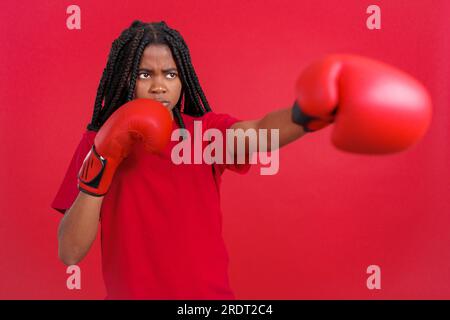Femme africaine faisant de la boxe de l'ombre avec des gants Banque D'Images