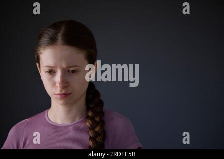 Low Key Studio Portrait d'une adolescente stressée inquiète des problèmes de santé mentale ou de l'intimidation Banque D'Images