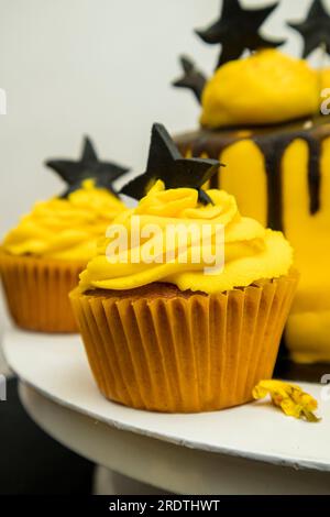 Cupcakes Halloween décorés de glaçage noir et jaune sur le dessus. Banque D'Images