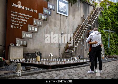 Duisburg, Allemagne. 23 juillet 2023. Un couple pleure au mémorial pour les victimes de la catastrophe de Love Parade. Le 24 juillet 2010, 21 personnes âgées de 17 à 38 ans sont écrasées à la seule entrée et sortie de la technoparade. Au moins 652 visiteurs de Love Parade ont été blessés à ce moment-là. Chaque année, les proches survivants commémorent les victimes. Crédit : Christoph Reichwein/dpa/Alamy Live News Banque D'Images