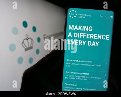 Personne tenant un smartphone avec la page Web de l'agence danoise de l'énergie Energistyrelsen sur l'écran devant le logo. Concentrez-vous sur le centre de l'écran du téléphone. Banque D'Images