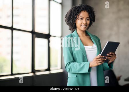 Portrait d'une femme d'affaires africaine à l'aide d'une tablette numérique travaillant sur le lieu de travail Banque D'Images
