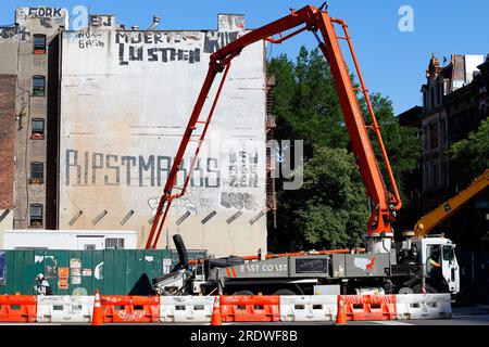 Un camion pompe à béton sur un chantier de construction de Manhattan East Village, New York. Le tombereau de pompage est doté d'une flèche extensible pour la portée. Banque D'Images