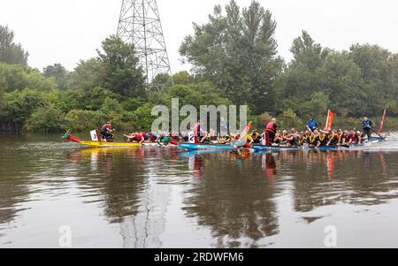 23 juillet 2023 - River Mersey, Warrington, Cheshire, Angleterre - un festival de bateaux-dragons organisé le long de la rivière Mersey à Warrington. Tenu au Rowing Club et malgré la pluie continue tout au long de la journée, un certain nombre de bateaux-dragons se sont affrontés pour trouver un gagnant éventuel. La « finale » était une course très serrée. L'événement visait à amasser des fonds pour l'Hospice St Rocco qui a pour objectif de fournir des soins de qualité et un soutien aux personnes et à leurs proches atteints d'une maladie limitant la vie qui vivent dans la région de Warrington pour permettre à chaque personne de trouver le confort, l'espoir, la force et la paix. Banque D'Images