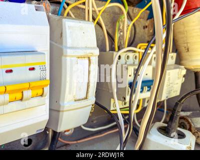 un panneau électrique avec de nombreux fils pour conduire la lumière vers les maisons des gens. bouclier maison avec une ampoule et des douilles. séparateurs de tension. Banque D'Images