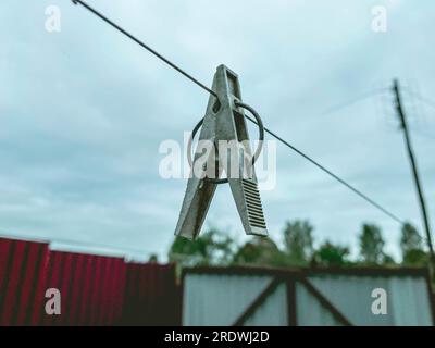 pince à linge accrochée à une corde à l'extérieur. séchage des vêtements après lavage sur une ficelle. pince à linge en bois avec anneau métallique. Banque D'Images