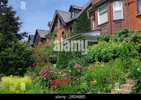 Rue avec vieilles maisons jumelées avec pignons et fleurs dans le jardin devant Banque D'Images