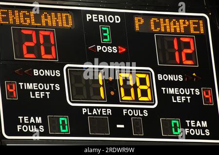 Match de basket-ball de l'école secondaire est dans le troisième trimestre et une équipe mène 20 à 12. Le tableau de bord est éclairé avec les statistiques de jeu. Banque D'Images