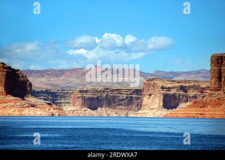 Le lac Powell en Arizona est entouré de falaises imposantes et offre des vues sur les chaînes de montagnes lointaines. Banque D'Images