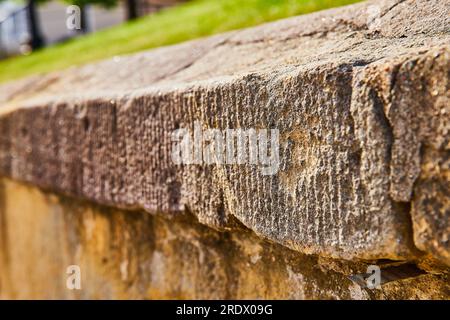 Gros plan du mur de béton usé par les intempéries avec de l'herbe au-dessus Banque D'Images