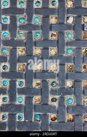 Motif entrecroisant avec des pierres de marbre bleu variables et manquantes entre les briques Banque D'Images