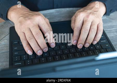 Homme d'affaires travaillant sur sa tablette en tapant sur le clavier. Vue de dessus, gros plan. Banque D'Images