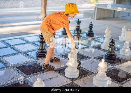 Père et fils jouant aux échecs et passant du temps ensemble à l'extérieur. Jeu d'échecs pour enfants Banque D'Images