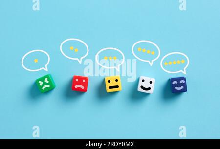 Satisfaction du client. Évaluation et évaluation du service ou du produit. Commentaires des utilisateurs et avis des clients. Cubes colorés avec émoticônes et notation de forme d'étoile Banque D'Images