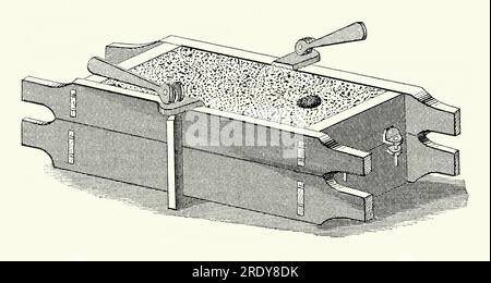 Une ancienne gravure d'un moule en sable (moule) pince des années 1800 Il est tiré d'un livre de génie mécanique victorien des années 1880 Le moulage au sable, également connu sous le nom de moulage au sable, est un procédé de moulage de métal caractérisé par l'utilisation de sable - connu sous le nom de sable de moulage - comme matériau de moulage. Les moulages au sable sont produits dans des usines spécialisées ou des fonderies. Le sable est généralement contenu dans un cadre ou une boîte connu sous le nom de flacon. La cavité de moule que le sable forme est appelée un motif – le métal fondu est versé dans le trou au sommet du moule et laissé refroidir. Le procédé est utilisé depuis des milliers d'années. Banque D'Images