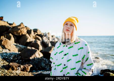 Jeune femme blonde debout près de la mer Banque D'Images