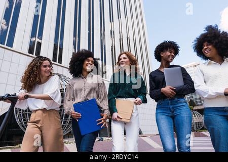 Femmes d'affaires heureuses ensemble marchant dans le parc de bureaux Banque D'Images