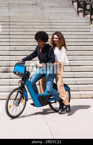 Heureux amis à vélo électrique sur la journée ensoleillée Banque D'Images