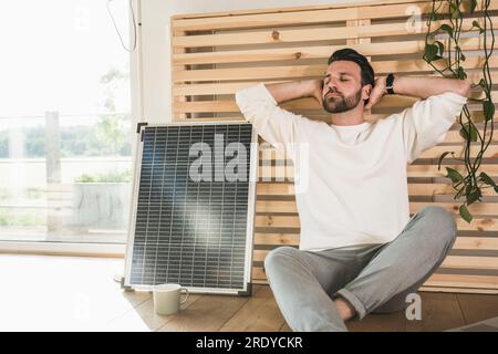 Homme d'affaires se détendant par panneau solaire à la maison Banque D'Images