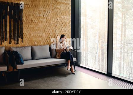Femme d'affaires attentionnée appréciant le café assis à la réception au centre de congrès Banque D'Images