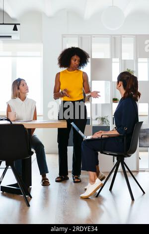 Femme d'affaires discutant avec des collègues en réunion au bureau créatif Banque D'Images