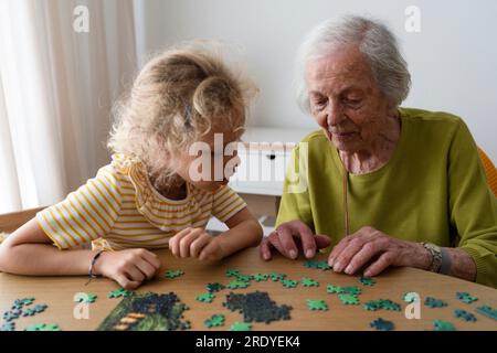 Grand-mère et petite-fille résolvant le puzzle Banque D'Images