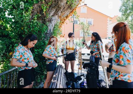 Groupe folklorique féminin avec des instruments de musique qui parlent entre eux Banque D'Images